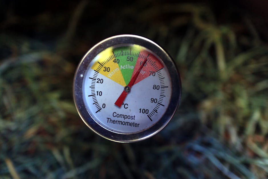 Close-up of a compost thermometer showing active temperature in a compost pile.